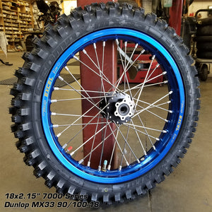 Woody's custom rear wheel for Sur Ron e-bike w/ blue Excel rim and black hub, w/ knobby tire mounted