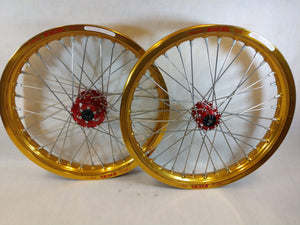 Woody's custom wheelset for Sur Ron e-bike featuring gold Excel rims w/ red billet hubs.