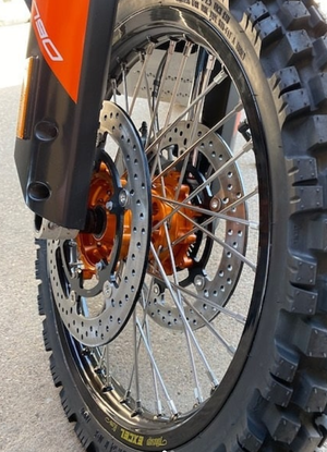 KTM front wheel mounted on a motorcycle w/ orange billet Woody's hub